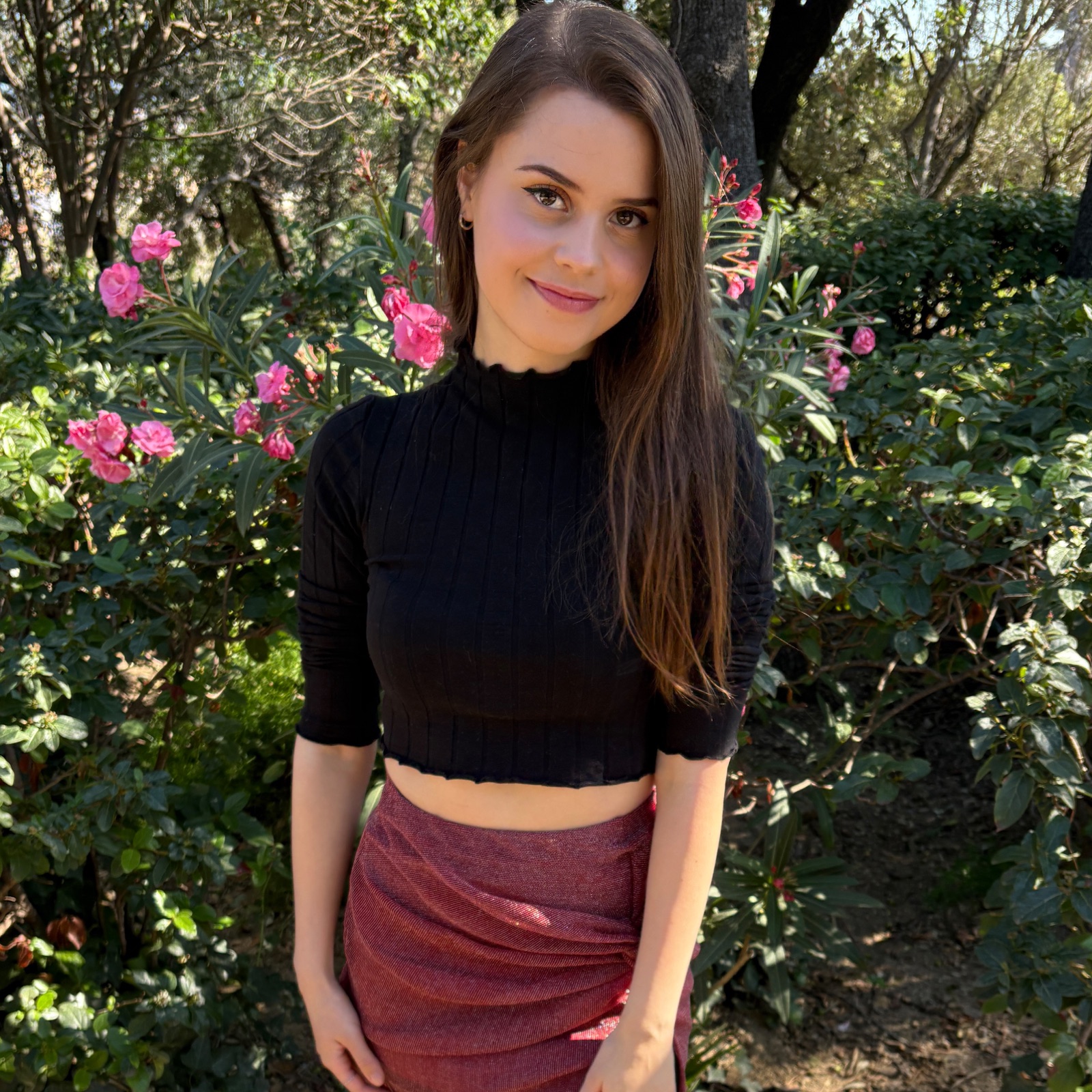 Jamie Young surrounded by pink flowers in a garden