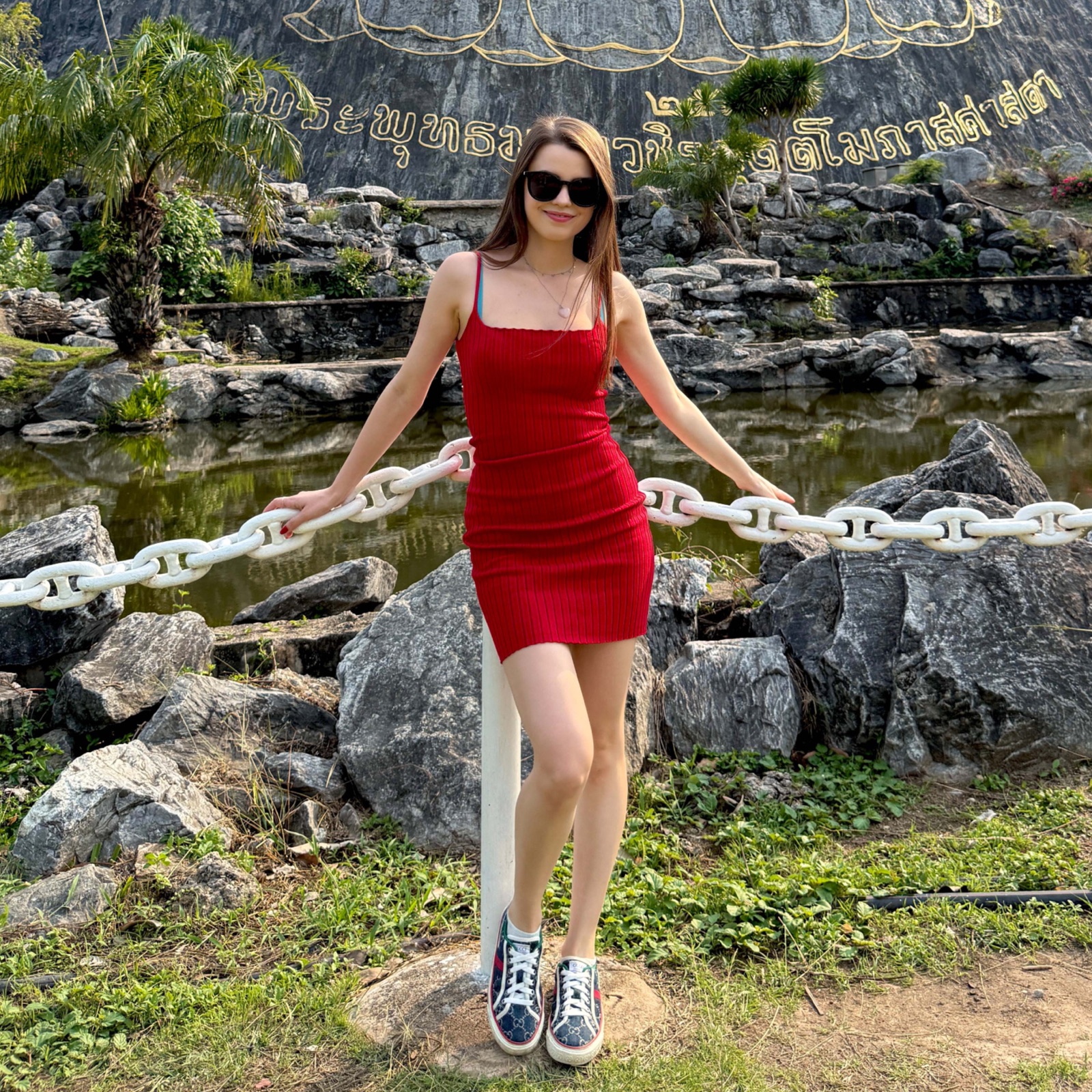 Jamie Young in a red dress in a tropical garden